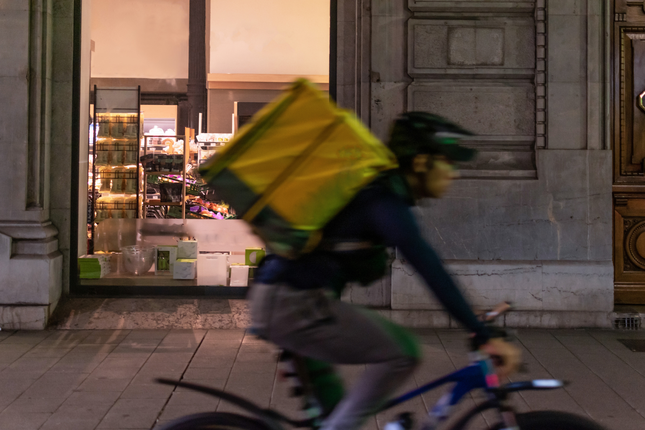 Repartidor en bicicleta por el centro de la ciudad por la noche