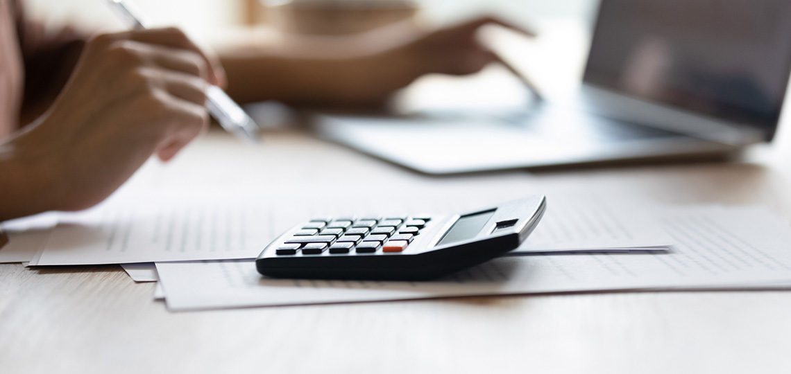 Calculadora con manos tecleando y escribiendo