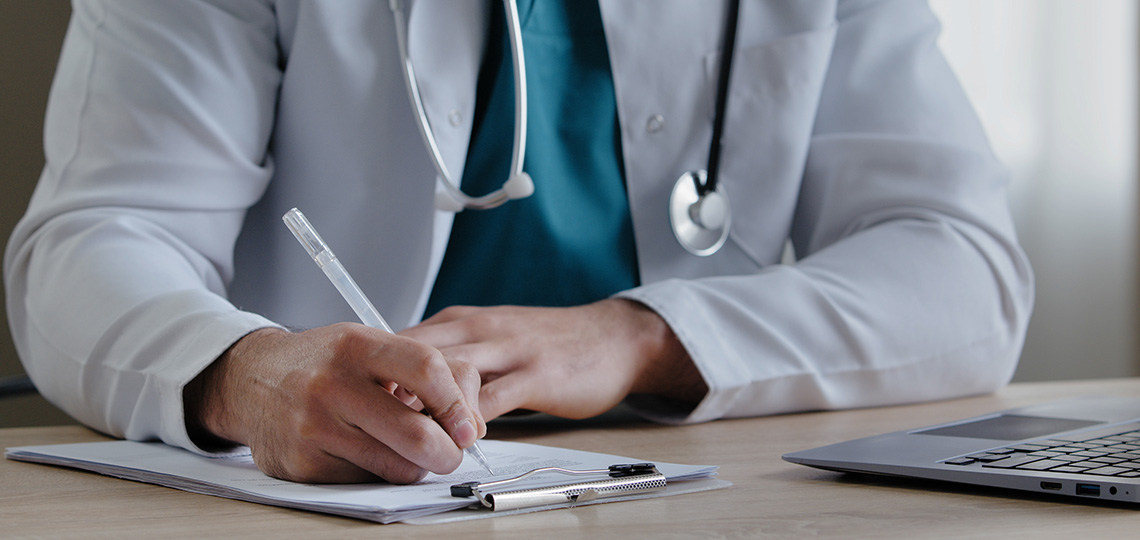Médico firmando un papel