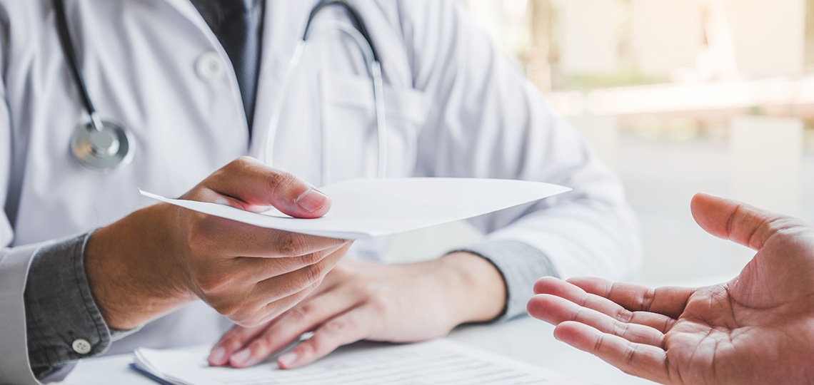 Médico entregando prescripción a paciente.