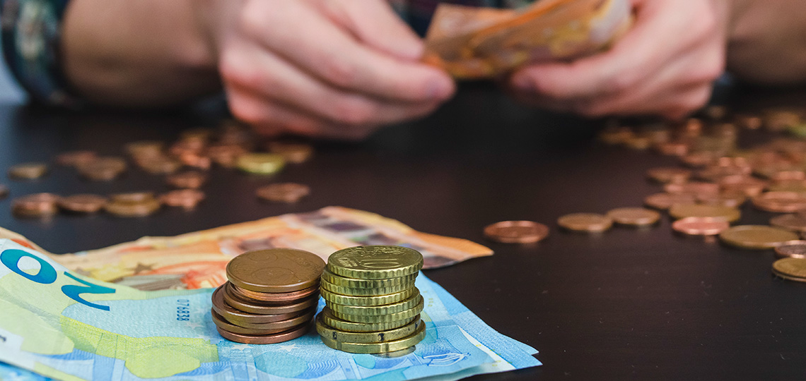 Persona contando dinero sobre una mesa