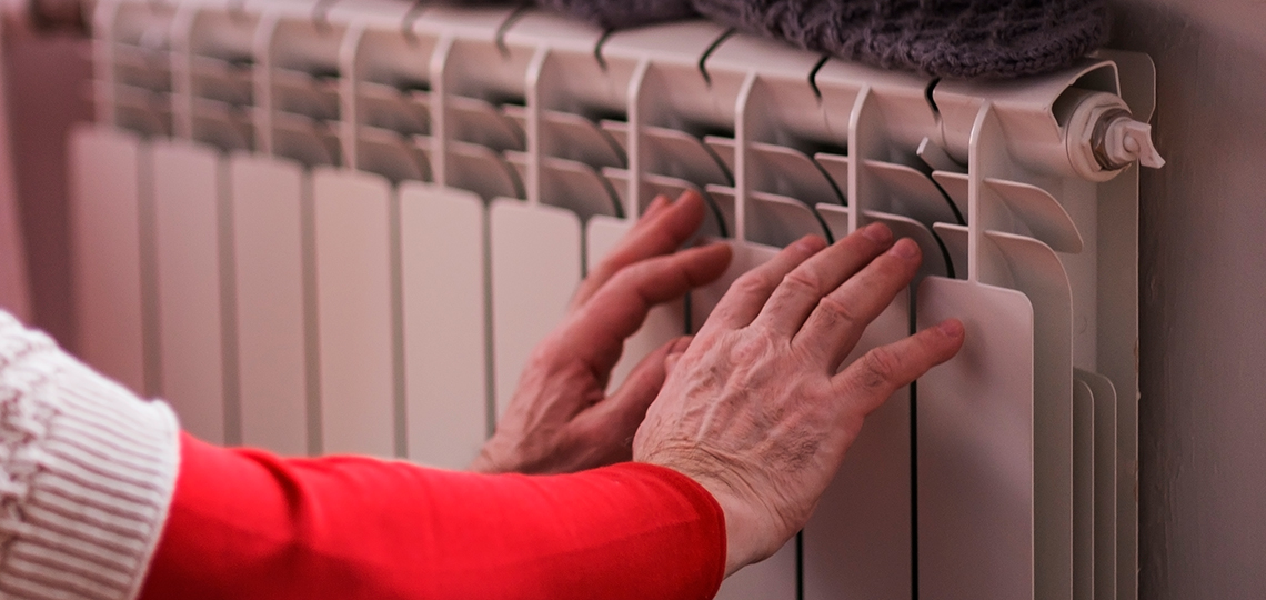 Manos acercándose a un radiador
